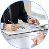 Eine Person im Anzug sitzt mit Stift, Notizbuch und Taschenrechner an einem Schreibtisch und schlägt eine Finanzplanung mit einem Steuerberater vor.