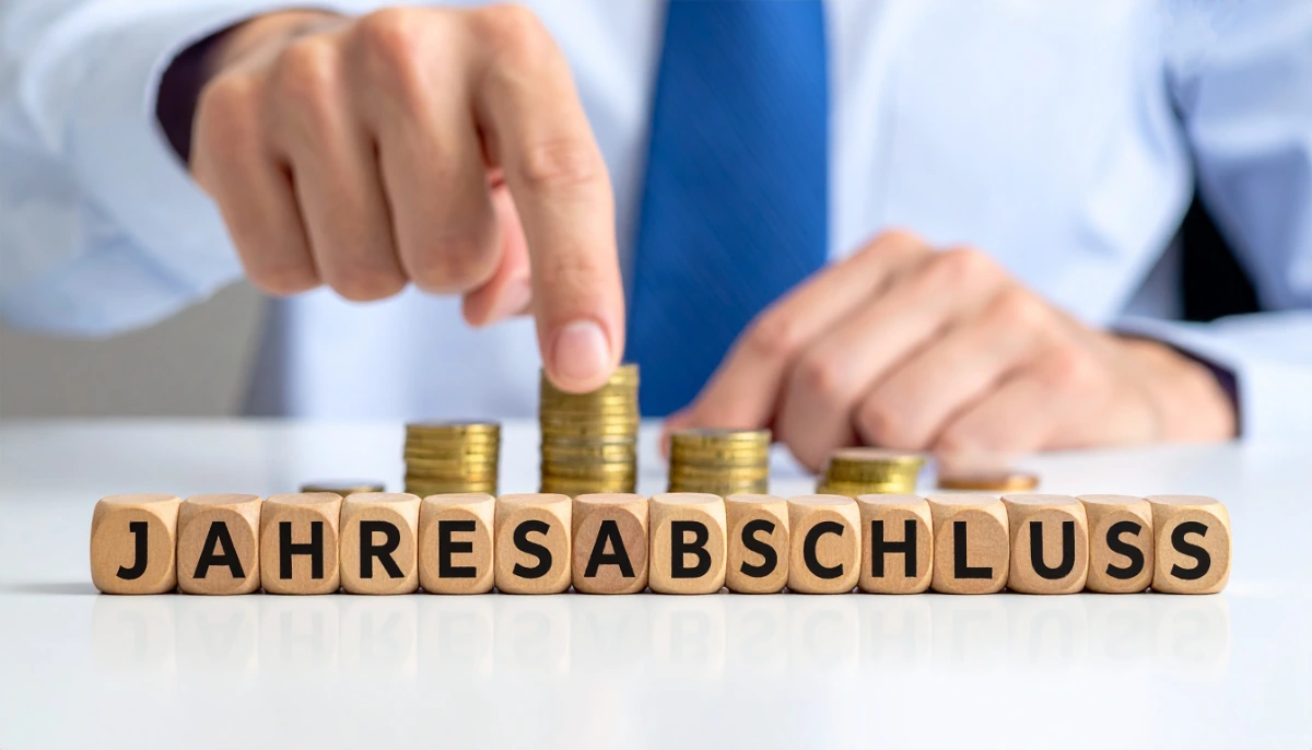 Bild von Münzhaufen, die hinter dem Titel “Jahresabschluss” aufgeschichtet sind und darauf hinweisen, dass bei einem Jahresabschluss in Form einer EÜR oder einer Bilanz der Gewinn ermittelt wird.